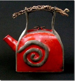A raku-fired ceramic teapot with a found-wood handle by Marcia DiSylvester, at the Clay Glass Metal Stone Gallery.