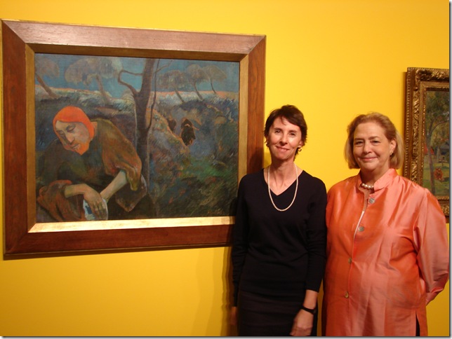 Cheryl Brutvan, the Norton Museum’s curator of contemporary art and the lead curator for the reinstallation, and Executive Director Hope Alswang stand beside Paul Gaugin’s Christ in the Garden of Olives (1889). (Photo by Jenifer Mangione Vogt) 