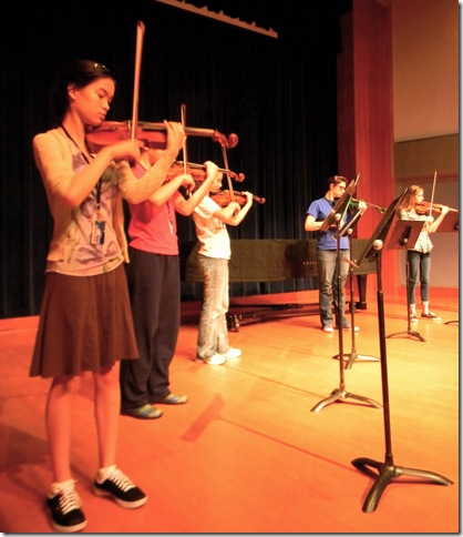 Students in the Stringendo School for Strings practice on stage at Palm Beach Atlantic University. (Photo by Chloe Elder) 