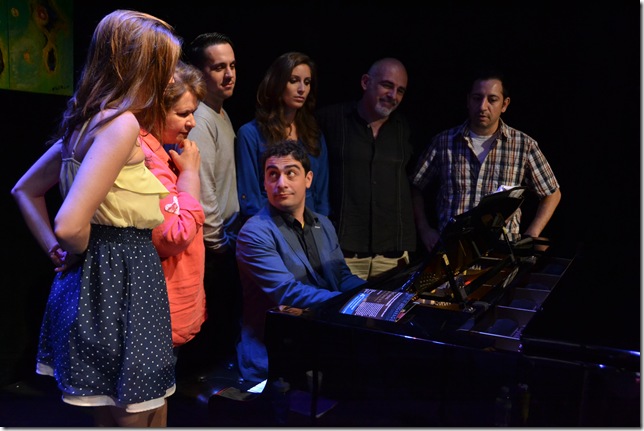Songwriter Daniel Maté at the piano, surrounded by the cast from The Longing and Short of It, at Arts Garage. From left: Liz Lark Brown, Elizabeth Dimon, Henry Gainza, Alix Paige, John Herrera and musical director Paul Reekie. (Photo by Amy Pasquantonio)