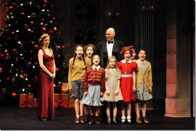 Emily Ferranti (left), as Grace Farrell, and Christopher Carl (center) as Daddy Warbucks, star with Clara Young (third from right) and the other orphans in the Maltz Jupiter Theatre’s production of ‘Annie.’ The orphans, from left: Emma Wallach, 12, of Palm Beach Gardens; Juliana Simone, 11, of Coral Gables; Sophia Liano, 9, of Stuart; Jenna McCoy, 9, of Royal Palm Beach; Young, 10, as Annie; Charlotte Krieger, 11, of Palm Beach Gardens; and Olivia Henley, 11, of Wellington. (Photo by Alicia Donelan)
